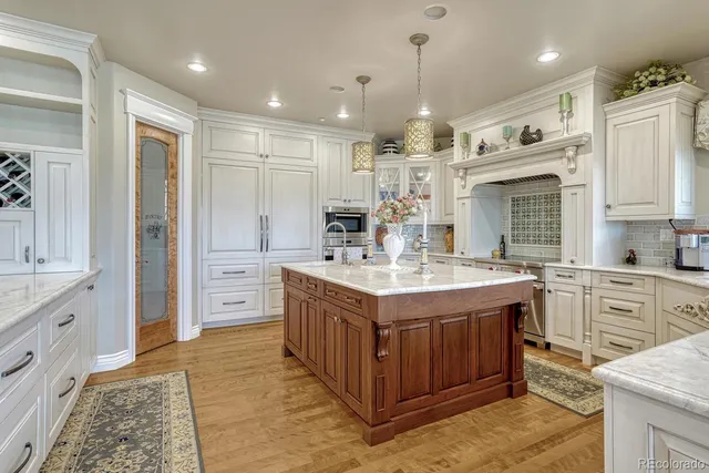 a kitchen with kitchen island granite countertop a stove and a refrigerator