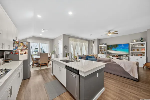 a large white kitchen with a large window and stainless steel appliances