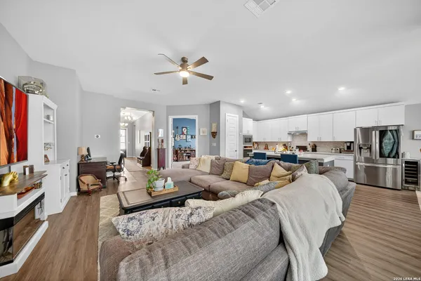 a living room with furniture kitchen view and a flat screen tv