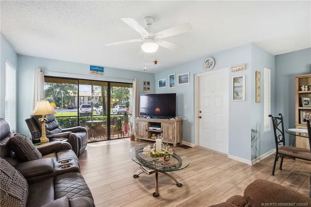 a living room with furniture a flat screen tv and a large window