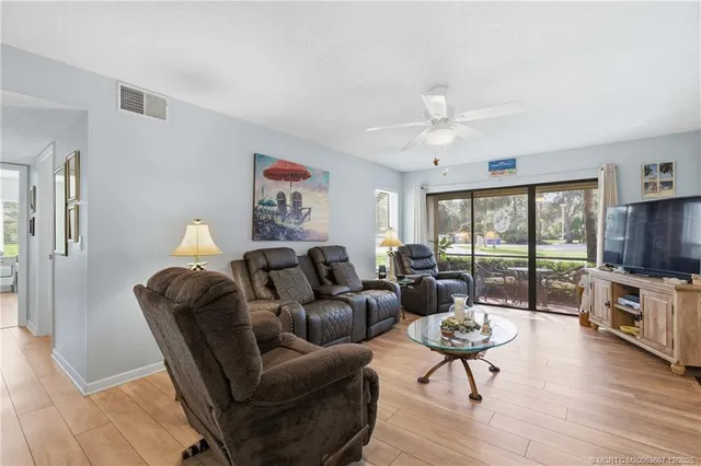 a living room with furniture a flat screen tv and a large window