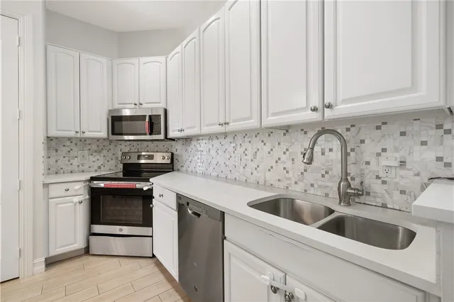 a kitchen with stainless steel appliances granite countertop a refrigerator sink and stove