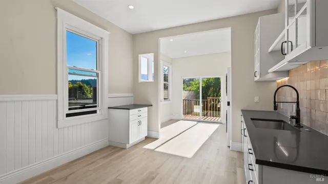 a kitchen with granite countertop a stove a sink and a window