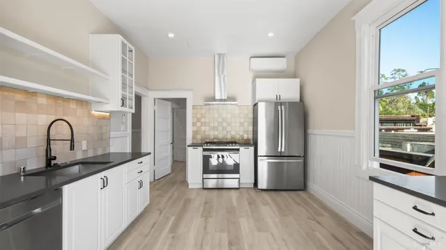 a kitchen with stainless steel appliances granite countertop a refrigerator and a stove top oven