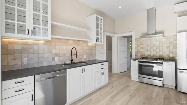 a kitchen with granite countertop white cabinets and stainless steel appliances