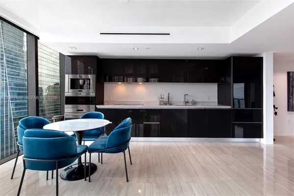a kitchen with granite countertop a sink cabinets and dining table