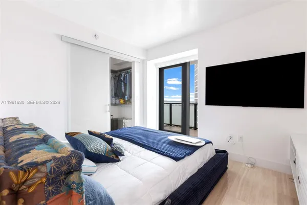 a bedroom with a bed and a flat screen tv