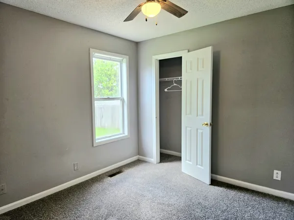 an empty room with windows and closet