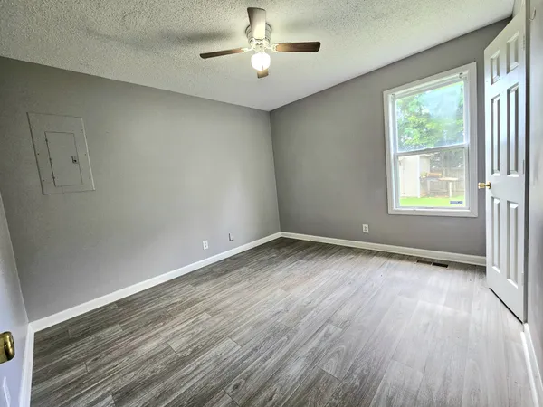 an empty room with a window and wooden floor