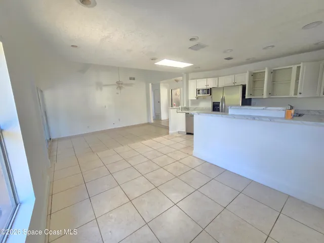 a view of an empty room with a floor to ceiling window and a swimming pool