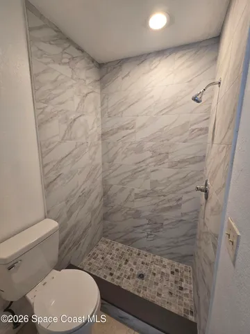 a bathroom with a toilet and a shower