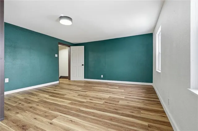 a view of empty room with wooden floor