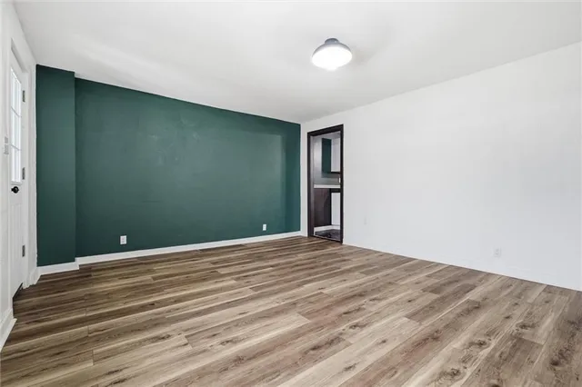 a view of an empty room with wooden floor