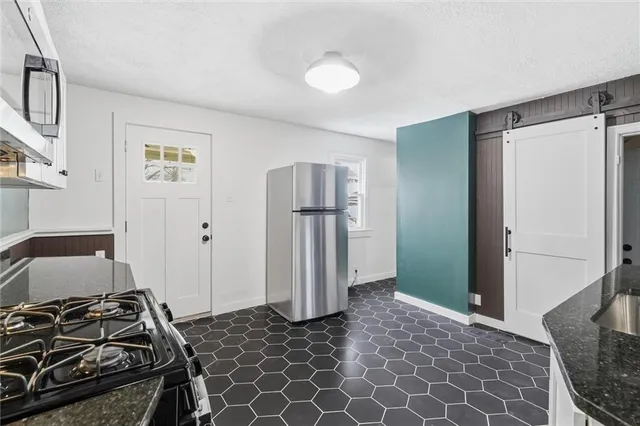 a bedroom with a bed and a refrigerator