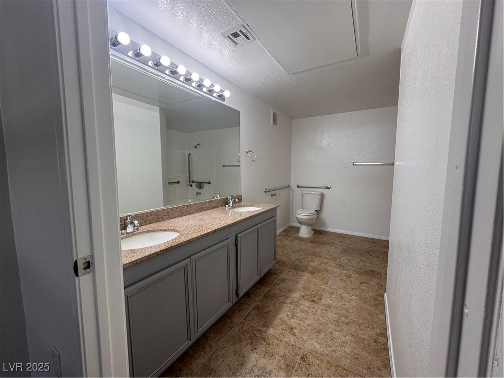 9975 Peace Way, Unit 1140 Las Vegas, NV 89147 - Photo 13 of 23 Bathroom featuring visible vents, a sink, a shower, and toilet