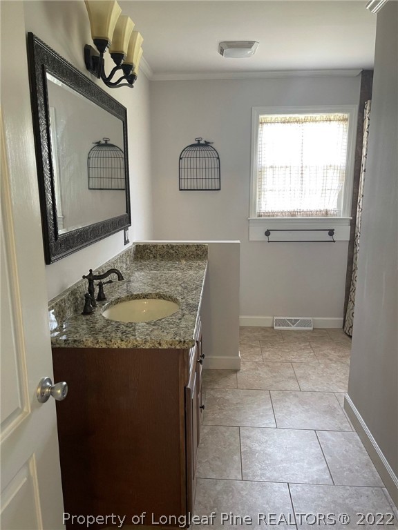1500 Meadowlark Road Dunn, NC 28334 - Photo 14 of 19 a bathroom with a granite countertop sink a mirror and vanity