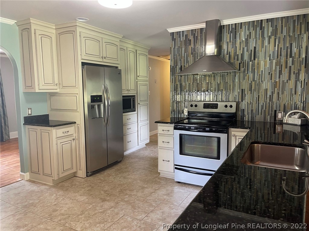 1500 Meadowlark Road Dunn, NC 28334 - Photo 5 of 19 a kitchen with stainless steel appliances a stove a refrigerator and cabinets