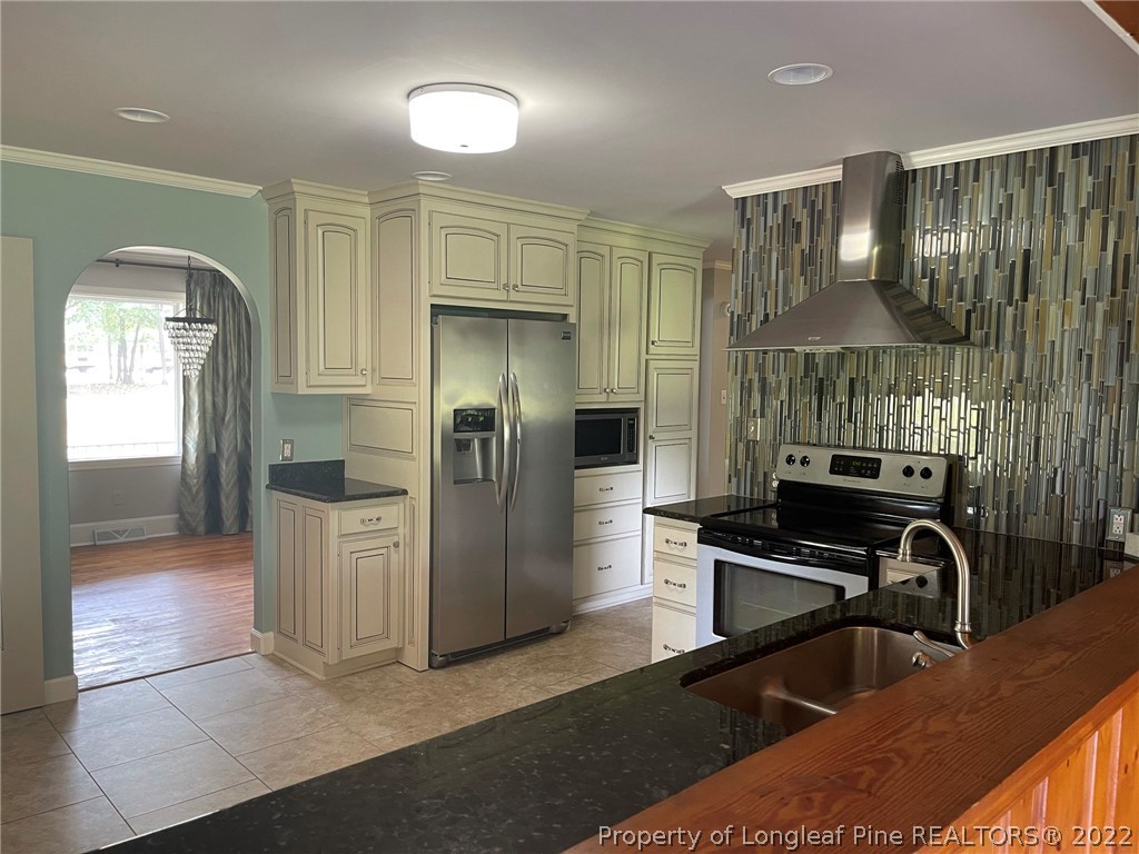 1500 Meadowlark Road Dunn, NC 28334 - Photo 6 of 19 a kitchen with stainless steel appliances granite countertop a refrigerator a stove and a sink