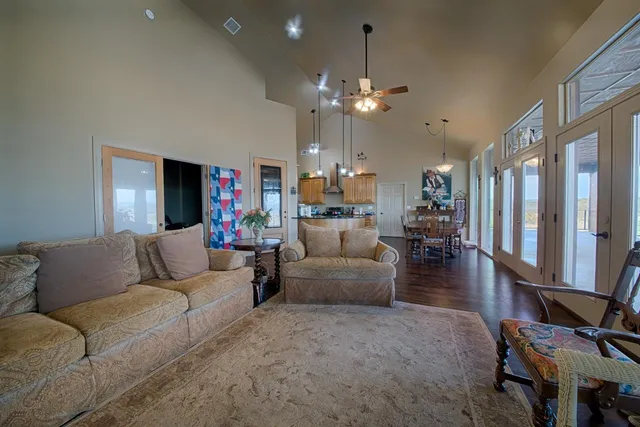 a living room with furniture kitchen view and a chandelier