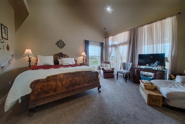 a spacious bedroom with a bed a couch and a window