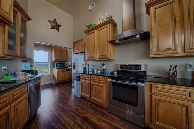 a kitchen with granite countertop wooden floors and stainless steel appliances