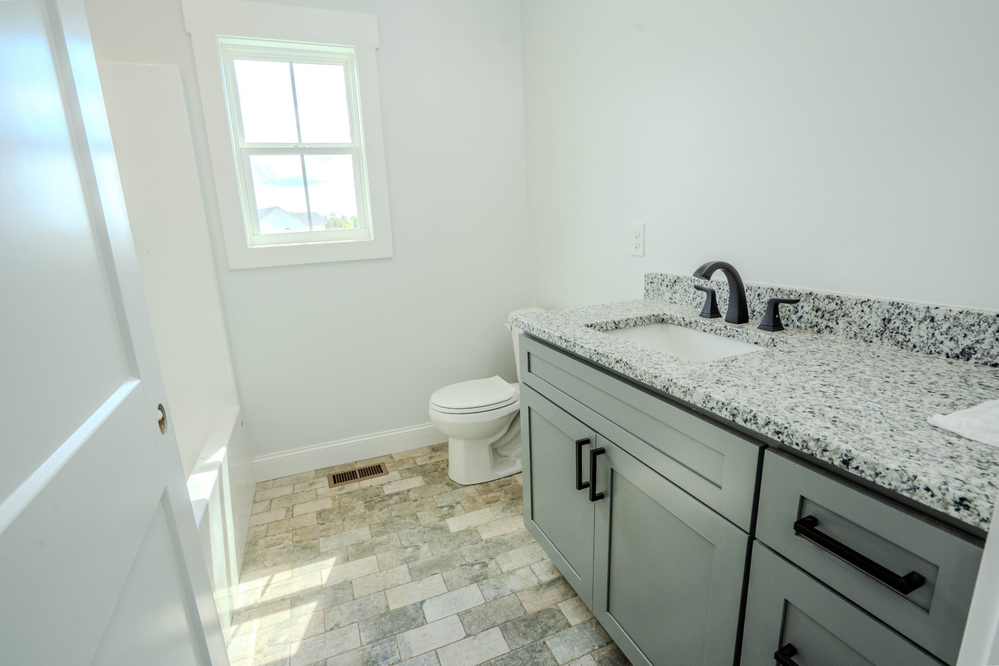 176 Beartown Road Loretto, TN 38469 - Photo 21 of 46 a bathroom with a granite countertop sink a toilet and a window