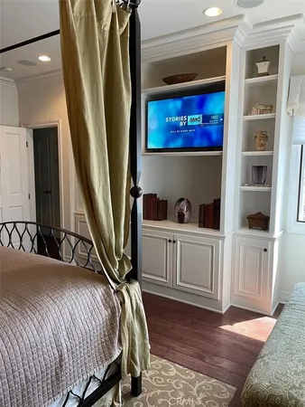 a bedroom with a bed and a large mirror on the dresser