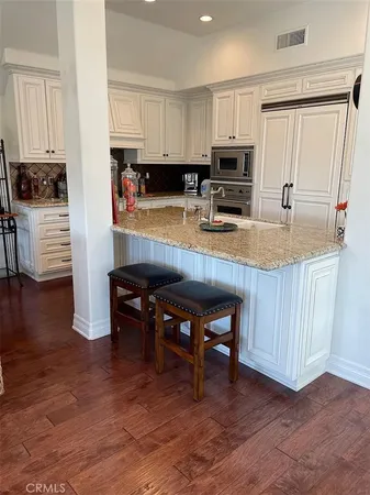 a kitchen with stainless steel appliances granite countertop a stove top oven a sink refrigerator and microwave