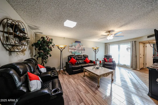 a living room with furniture and a wooden floor
