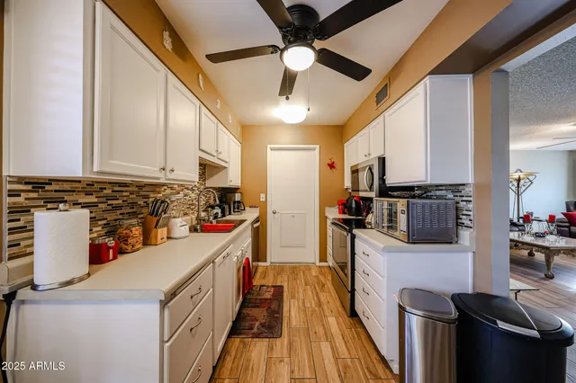 a kitchen with stainless steel appliances a stove top oven a sink a refrigerator and cabinets