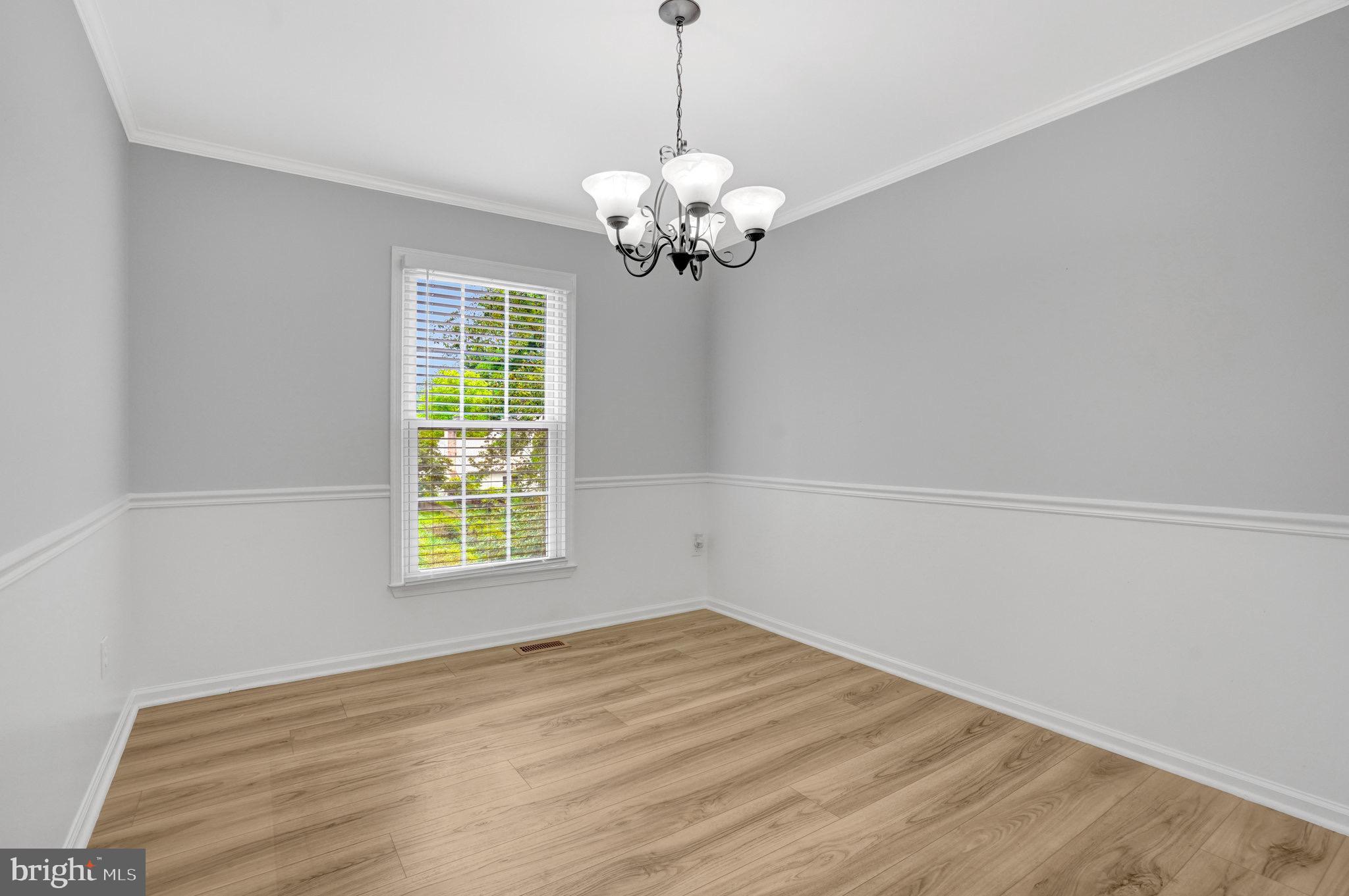 8298 Lindside Way Springfield, VA 22153 - Photo 11 of 38 a view of a room with a chandelier and wooden floor