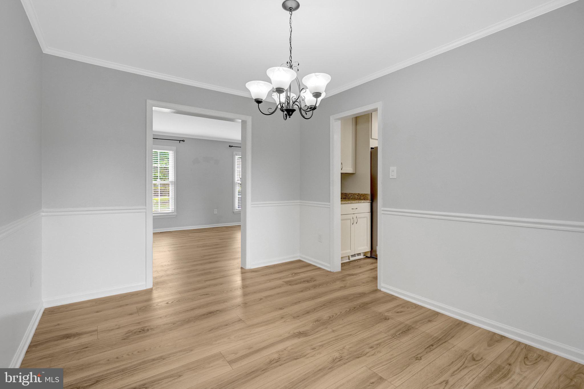 8298 Lindside Way Springfield, VA 22153 - Photo 12 of 38 a view of an empty room with wooden floor and chandelier