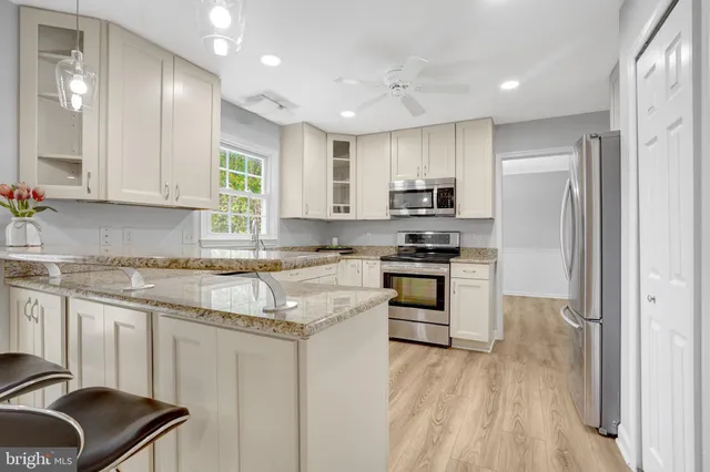 a kitchen with granite countertop a stove a sink and a refrigerator