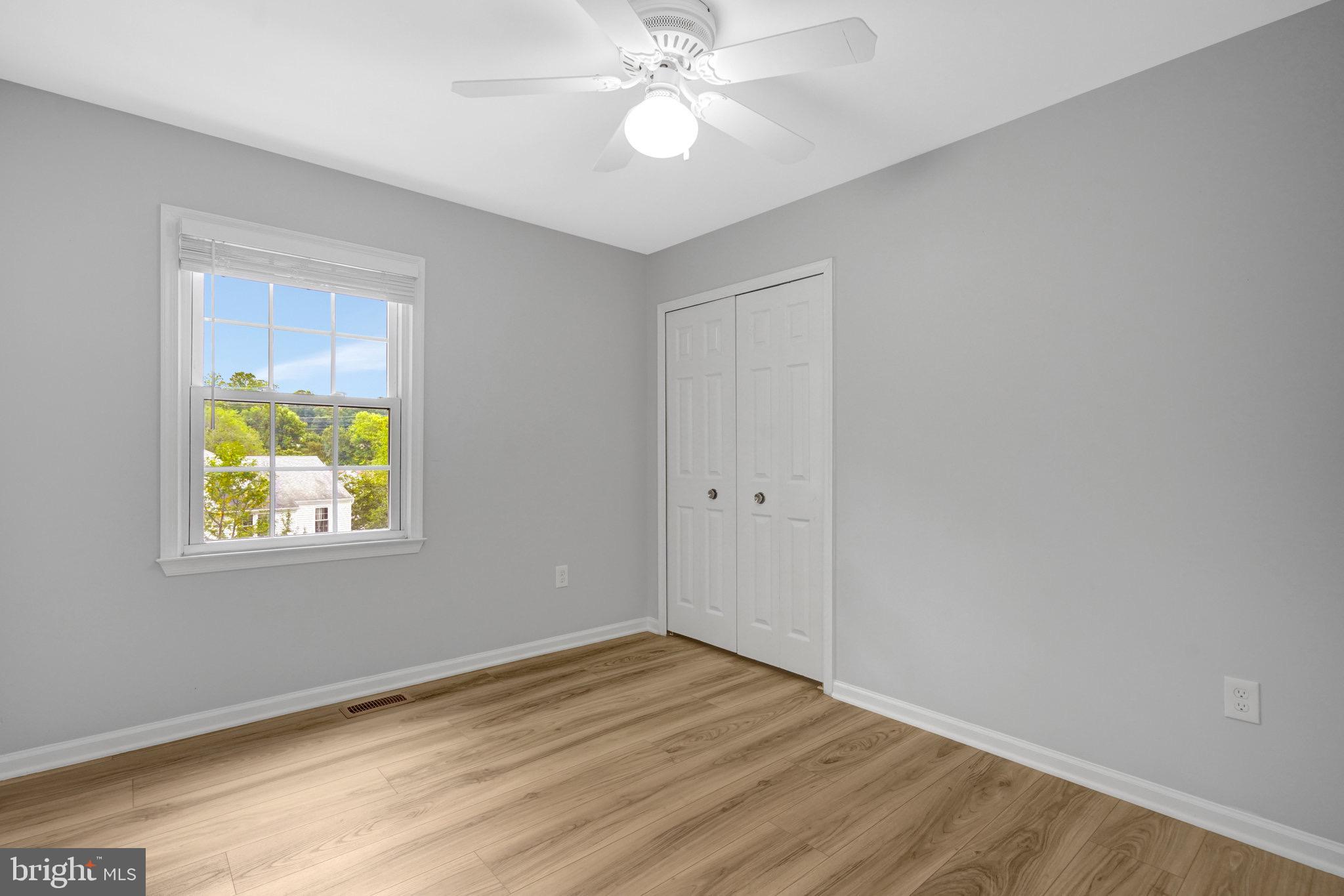 8298 Lindside Way Springfield, VA 22153 - Photo 18 of 38 a view of an empty room with window and wooden floor