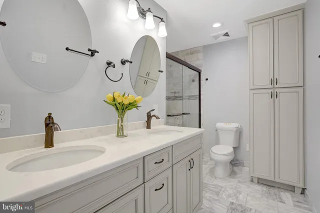 a bathroom with a granite countertop sink a toilet and mirror