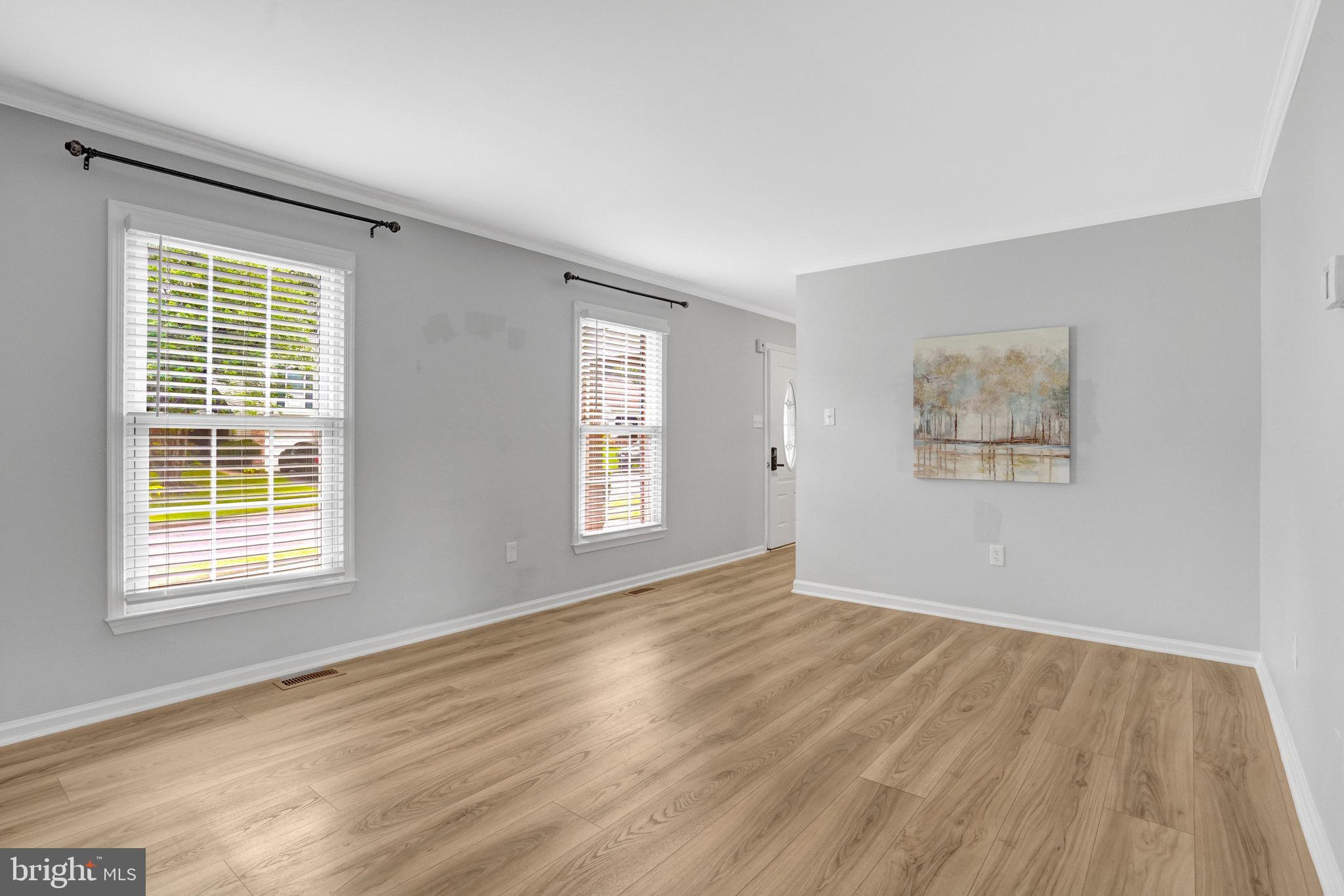 8298 Lindside Way Springfield, VA 22153 - Photo 10 of 38 a view of an empty room with wooden floor and a window