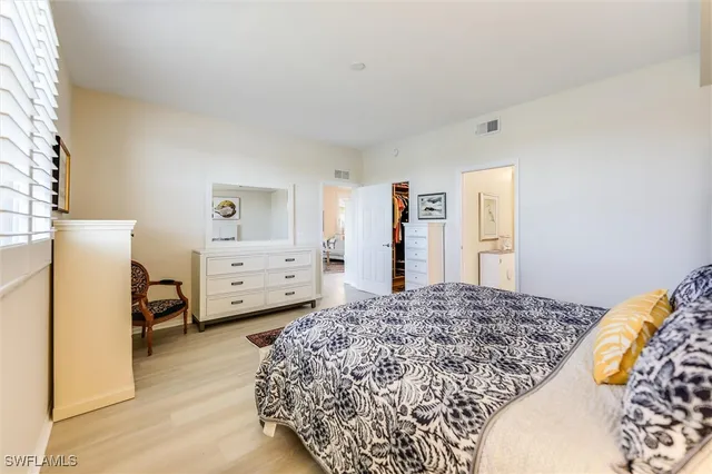 a bedroom with a bed and a refrigerator