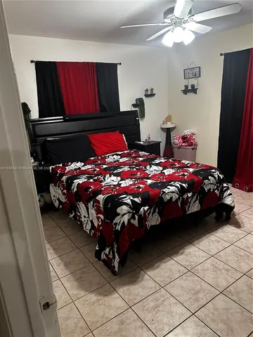 a bedroom with bed and a flat tv screen