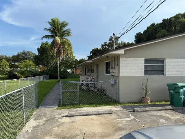 a view of a house with a yard and potted plants