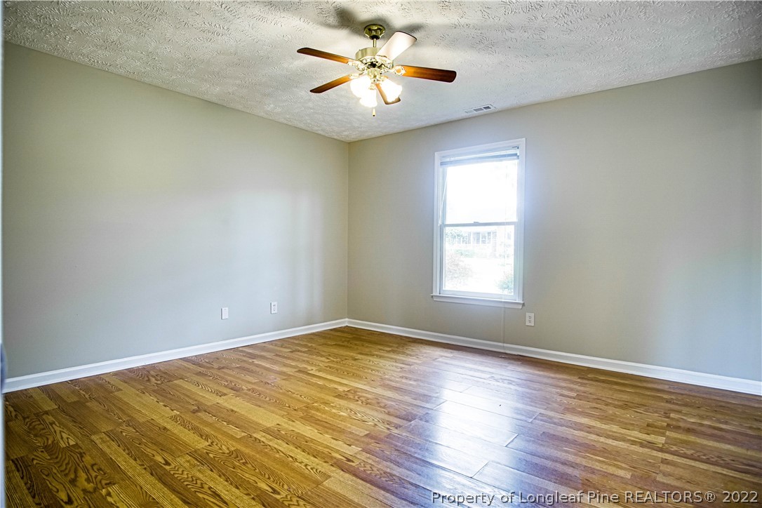 1810 Nuthatch Road Fayetteville, NC 28304 - Photo 12 of 37 wooden floor in an empty room with a window