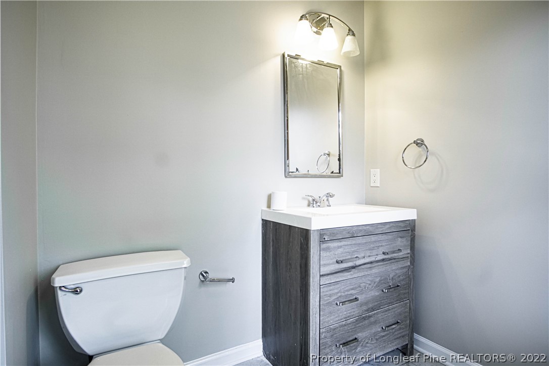 1810 Nuthatch Road Fayetteville, NC 28304 - Photo 17 of 37 a bathroom with a toilet a sink and mirror