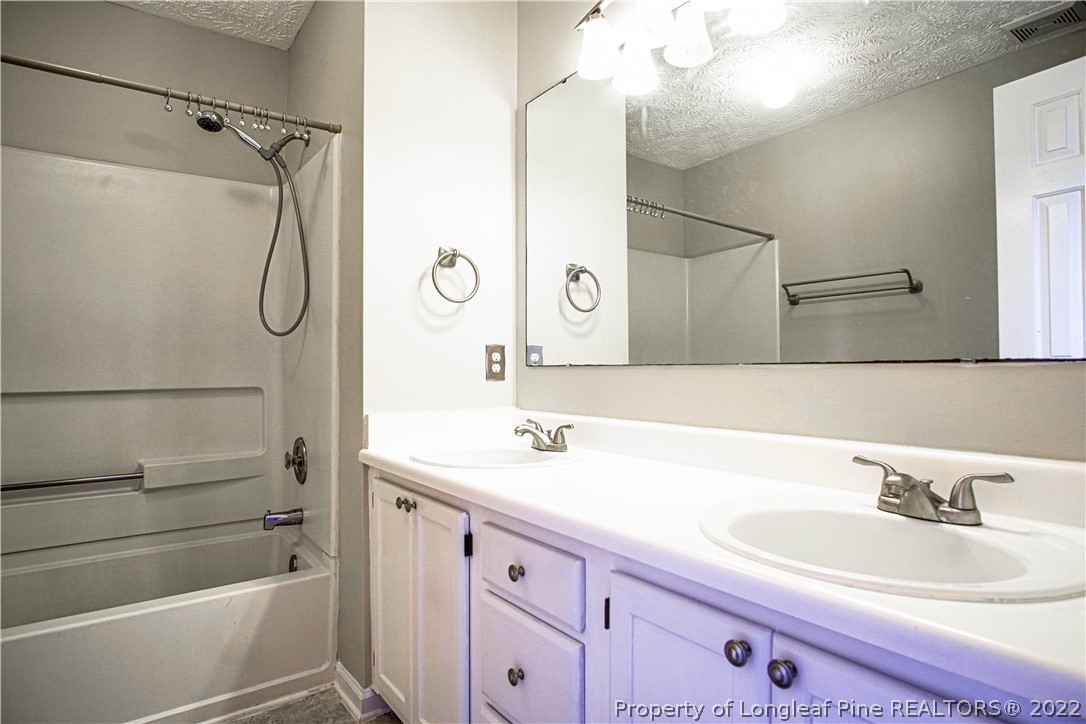 1810 Nuthatch Road Fayetteville, NC 28304 - Photo 24 of 37 a bathroom with a double vanity sink mirror and shower
