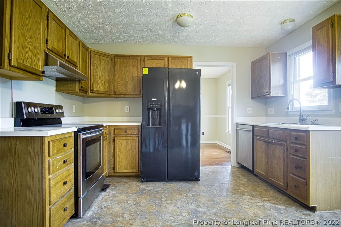 1810 Nuthatch Road Fayetteville, NC 28304 - Photo 4 of 37 a kitchen with stainless steel appliances granite countertop a refrigerator a stove top oven a sink and dishwasher