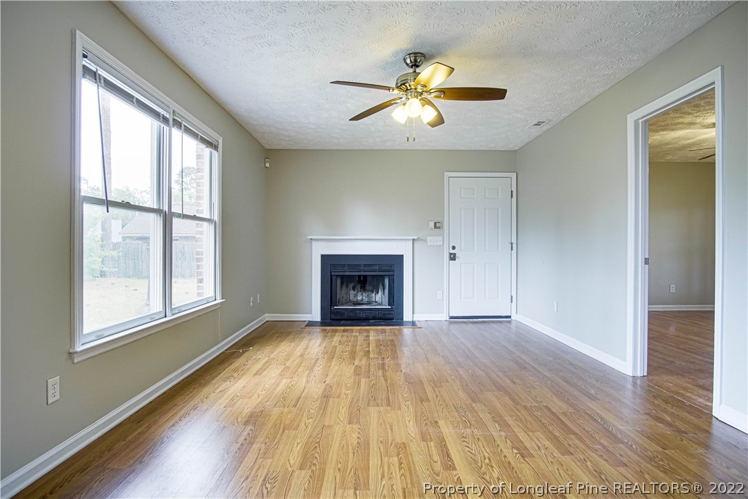1810 Nuthatch Road Fayetteville, NC 28304 - Photo 6 of 37 an empty room with wooden floor fan and windows
