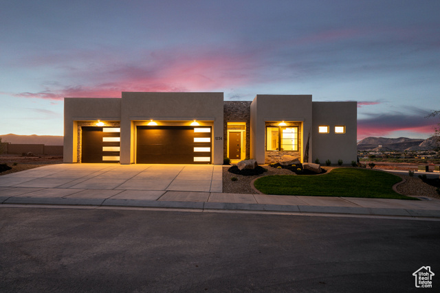 1234 West Firepit Dr Street St. George, UT 84770 - Photo 1 of 1 View of front of house featuring a garage, stucco siding, driveway, a lawn, and a mountain view