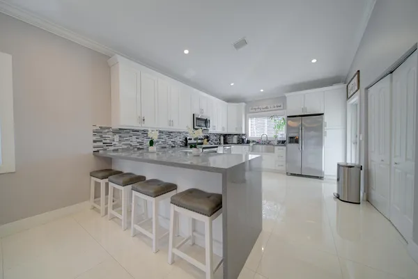 a kitchen with white cabinets and stainless steel appliances