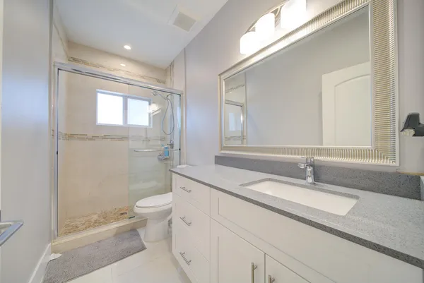 a bathroom with a sink a toilet and shower