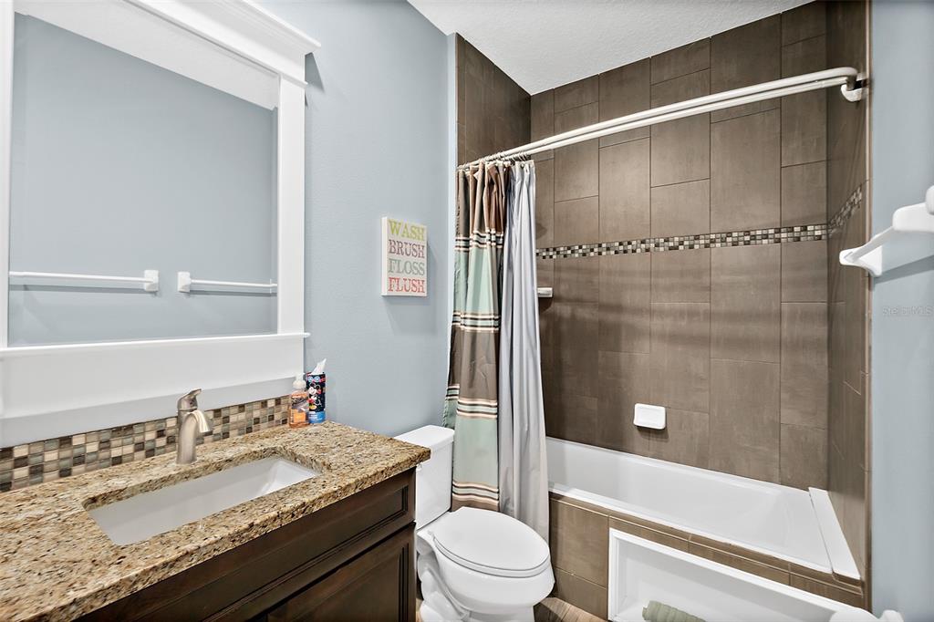 4895 State Rte 100 Bunnell, FL 32110 - Photo 34 of 45 a bathroom with a granite countertop sink toilet and shower