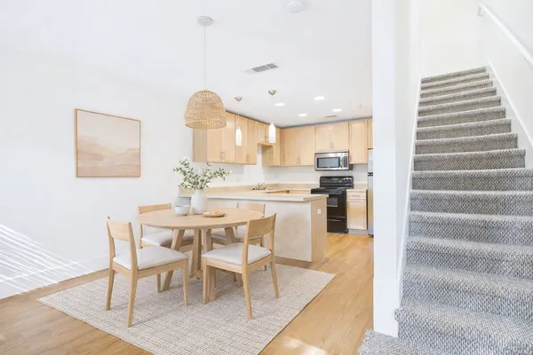 a kitchen with a table chairs refrigerator and cabinets
