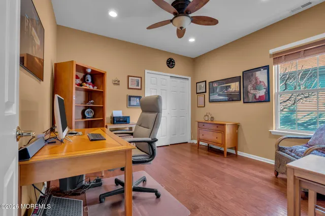 a kitchen with stainless steel appliances granite countertop a stove top oven a sink a dining table and chairs with wooden floor